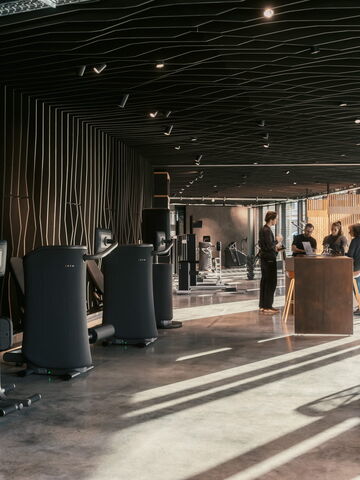 Ein modernes Fitnessstudio in Bochum, wo Trainer und Klienten über Training und Physiotherapie sprechen.