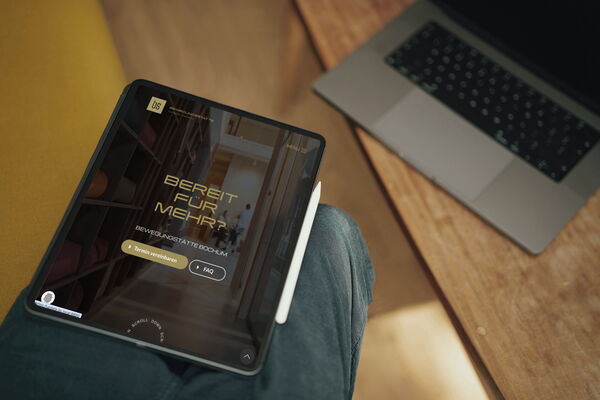 Ein Tablet zeigt die Webseite einer Physiotherapie in Bochum, die Training und Yoga anbietet, auf einem Holztisch.