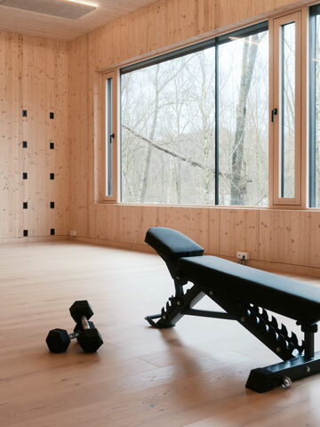 Ein gut beleuchteter Raum in Bochum mit einer Fitnessbank und Hanteln, ideal für Training und Physiotherapie.