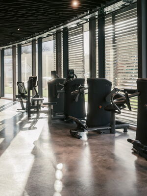 Ein modernes Fitnessstudio in Bochum mit Trainingsgeräten und einer Gruppe, die sich am Empfang unterhält.