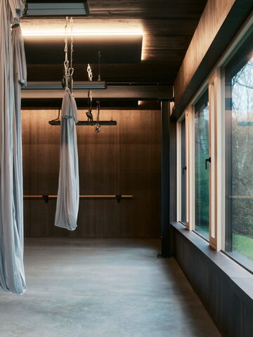 Ein heller Raum in Bochum mit hängenden Tüchern, ideal für Yoga-Training und Physiotherapie.