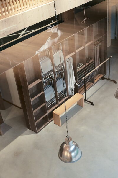 Ein moderner Raum in Bochum, bereit für Fitness- und Yoga-Training, mit stilvollen Lichtinstallationen und Holzregalen.