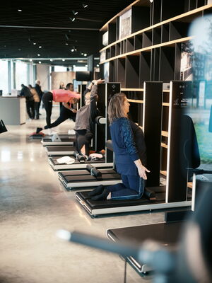 Gruppen von Menschen üben gezielte Yoga- und Physiotherapie-Übungen in einem modernen Fitnessstudio in Bochum.