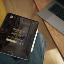 Ein Tablet zeigt die Webseite einer Physiotherapie in Bochum, die Training und Yoga anbietet, auf einem Holztisch.