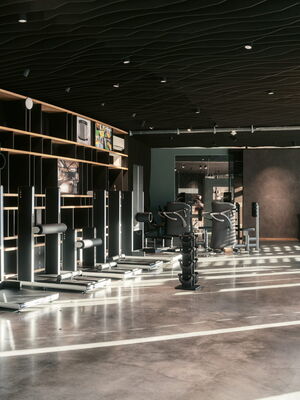 Ein moderner Fitnessraum in Bochum mit Trainingsgeräten und elegantem Design, ideal für Physiotherapie und Yoga.