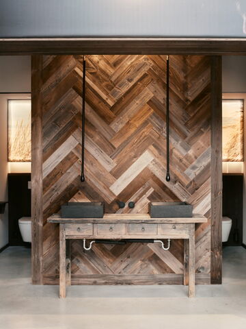 Elegantes Badezimmer mit einer Holzvertäfelung und einem stilvollen Waschtisch aus Holz im modernen Design.