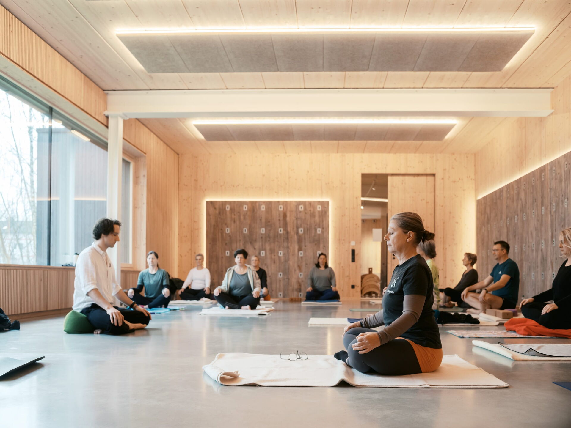 Eine Gruppe von Teilnehmern praktiziert Yoga in einer hellen Physiotherapie-Einrichtung in Bochum.